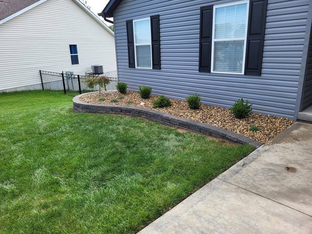 Block-edged bed along a blue house